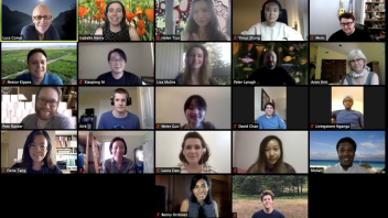 Zoom grid of lab meeting with many participants, each smiling in virtual frames, some with nature or bookcase backgrounds.